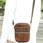 Brown leather crossbody bag worn cross-body, front flap and top zip pocket with strap