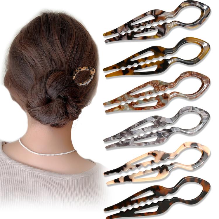 Assorted tortoiseshell U-shaped 2-prong fish bun holder hair pins next to a bun.