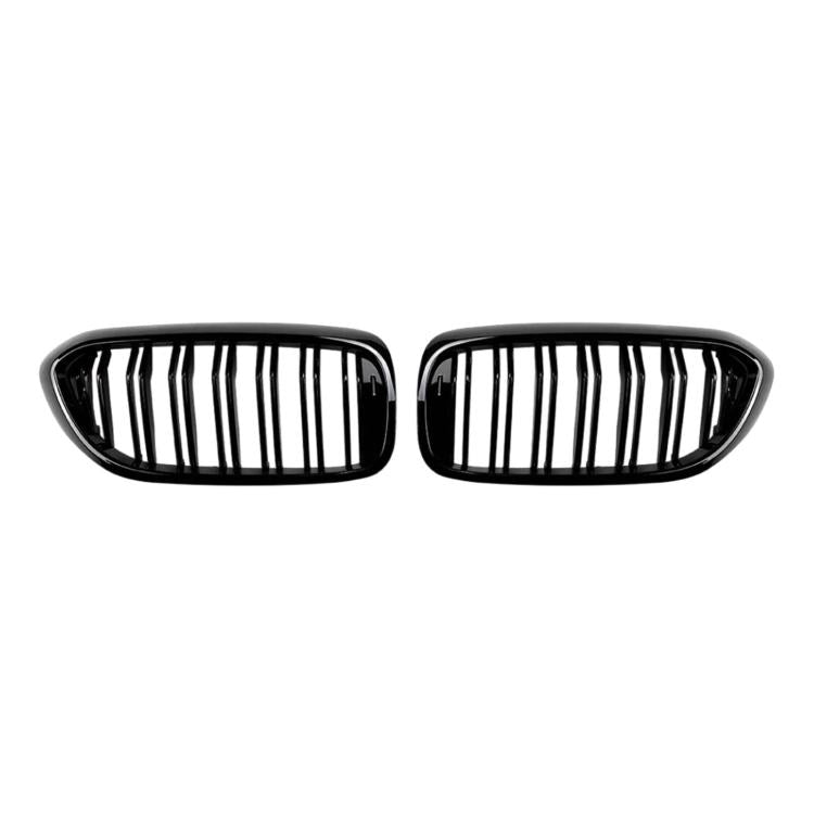 Two black oval grille inserts with vertical slats and glossy trim