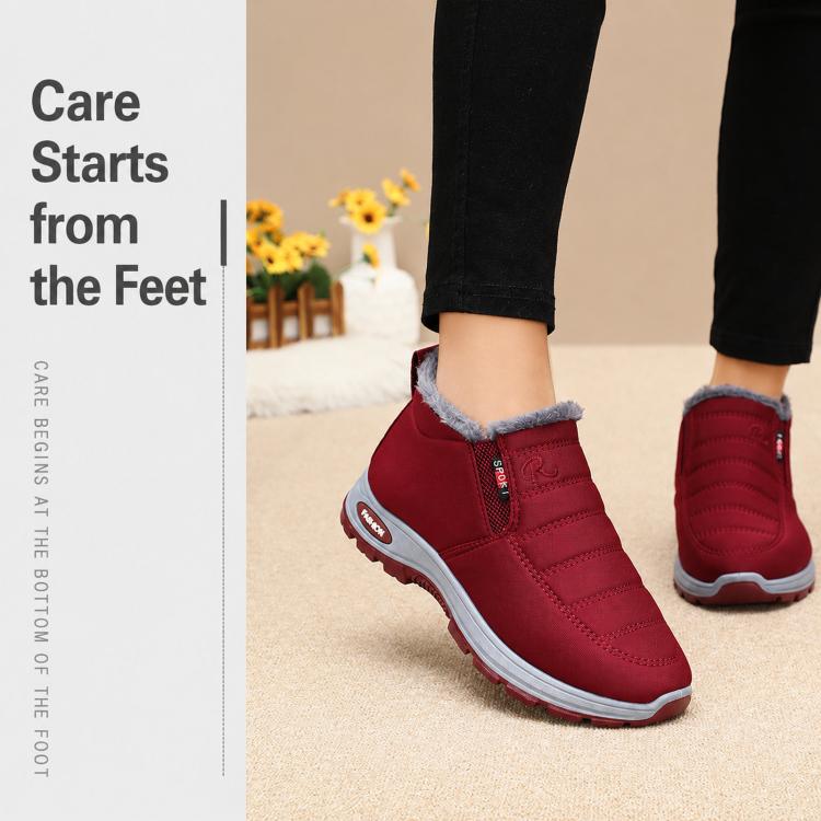 Red fleece-lined slip-on winter boots with textured sole, worn by model