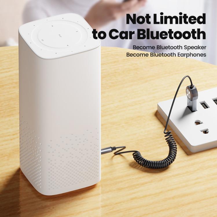Bluetooth AUX adapter cable with 3.5mm plug connected to a small white speaker