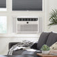 Installed window AC with white insulated side filler accordion panel