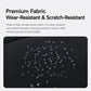 Black water-resistant fabric backpack with water droplets on textured surface.