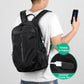 Black laptop backpack on person with front charging port and zippered compartments.