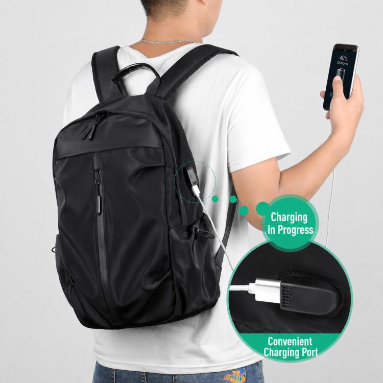 Black laptop backpack on person with front charging port and zippered compartments.