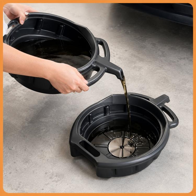 Oil drain pan filling with fluid, black plastic basin with handles and pour spout