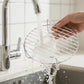 Stainless grill rack being rinsed under running water