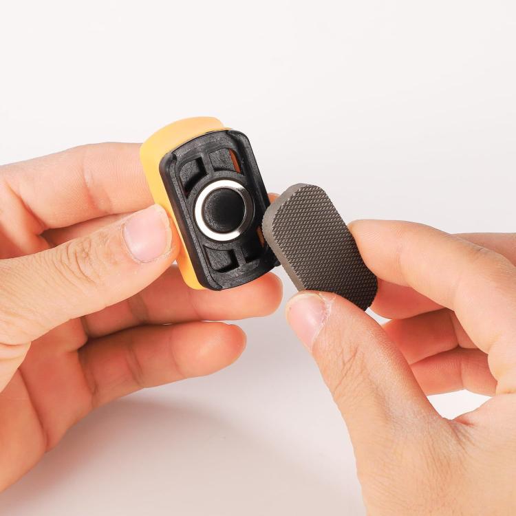 Mini magnetic paint file held in hands; black frame with round metal magnet and textured pad