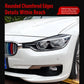 Installed headlight eyebrow decals on a BMW front headlamp, dark curved trim pieces