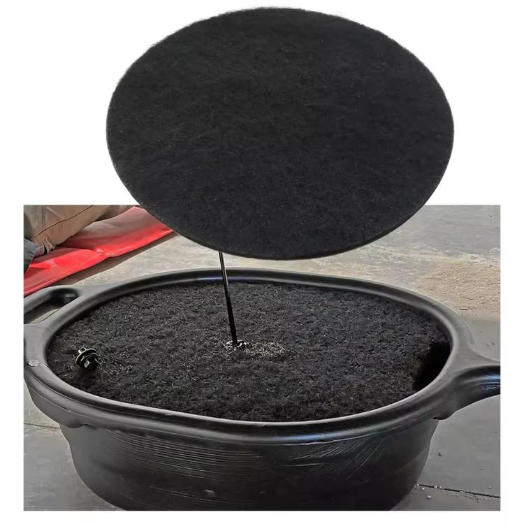 Black round oil drain splash pad mat covering a drain pan opening