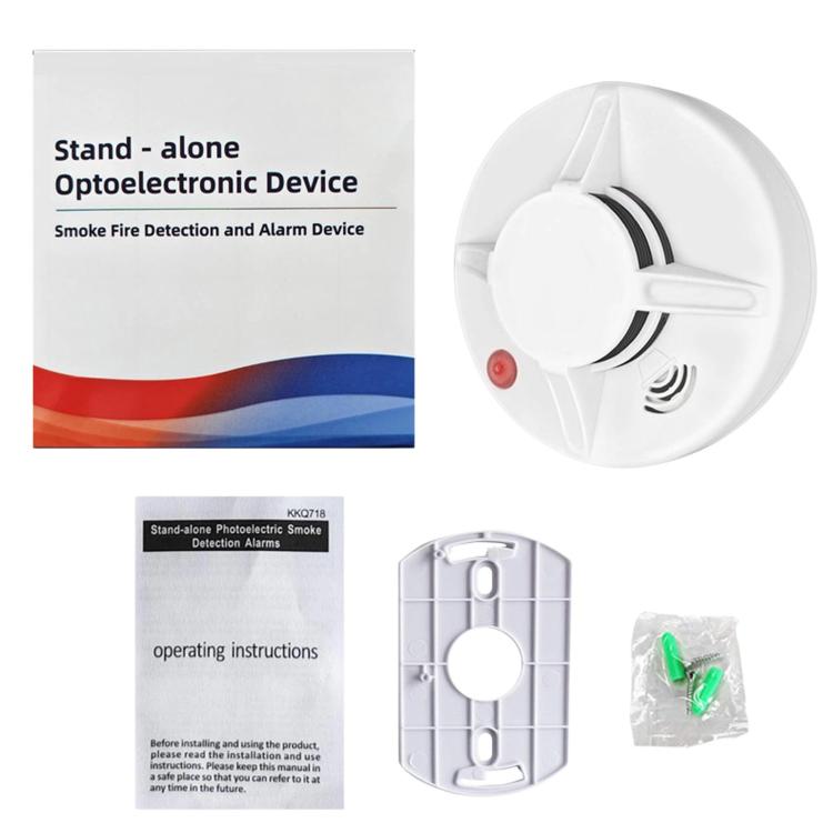 White standalone smoke alarm with red status light, shown next to packaging materials