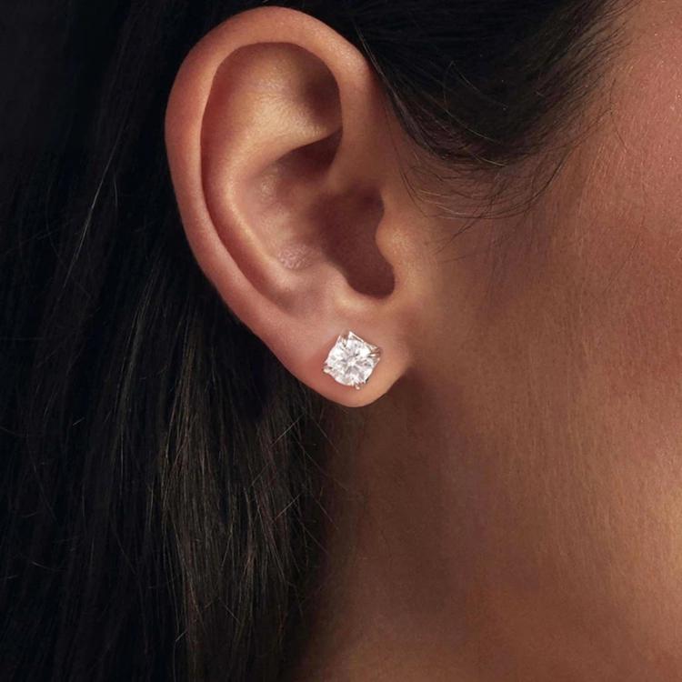 Sterling silver square moissanite stud earrings with sparkling center stone, worn