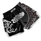 Muay Thai boxing shorts in black and white with dragon crest graphic on front.