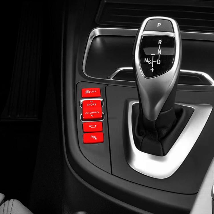 Car gear shift switch buttons set with red caps on center console beside shifter