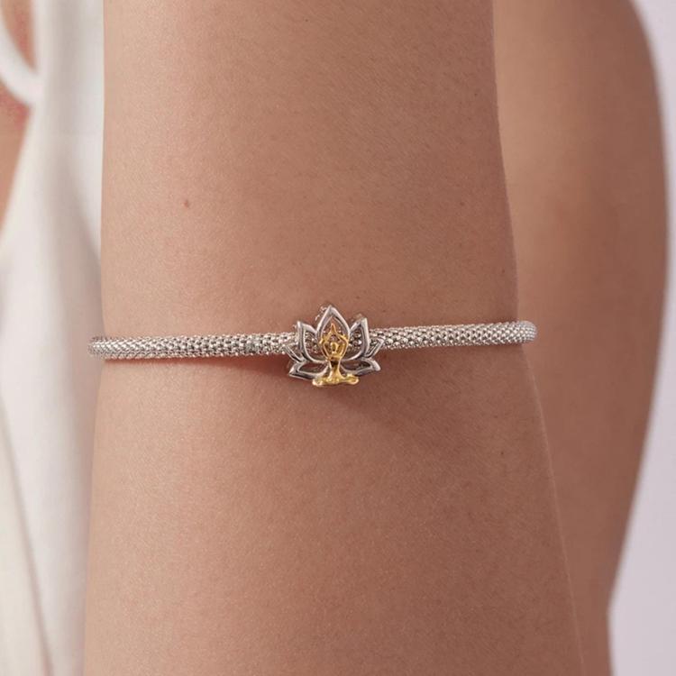 Lotus yoga bead bracelet on wrist, silver chain with gold-and-silver lotus charm