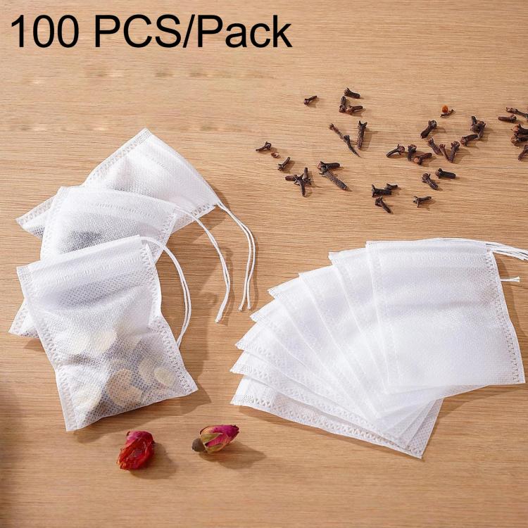 White non-woven tea filter bags, drawstring style, with loose herbs inside
