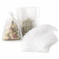 Pack of white non-woven tea filter bags, one filled bag with drawstring