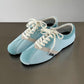 Blue fabric lace-up sneakers with white laces and beige side stripe, flat sole