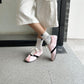 Pink lace-up sneakers worn with white socks, flat low-profile sole