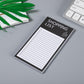 Magnetic shopping list notepad with black cover, 'SHOPPING LIST' title, and ruled lines