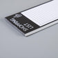 Shopping list pad close-up of black cover edge with lined sheet beneath