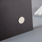 Round magnet on dark backing of shopping list pad