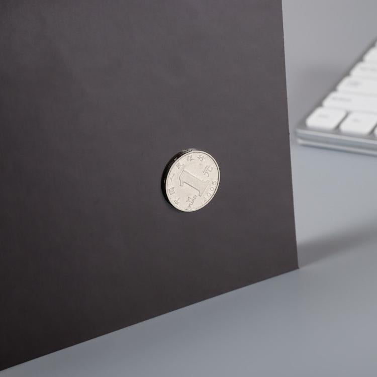 Round magnet on dark backing of shopping list pad