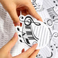 Hand placing a music staff sticky note with treble clef symbol onto paper surface