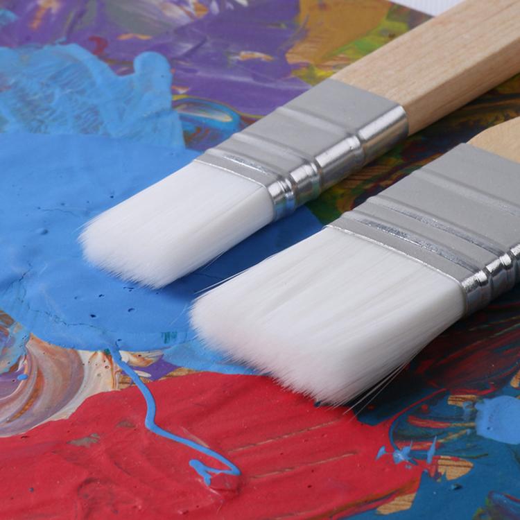 Two paintbrushes with white synthetic bristles on multicolor paint
