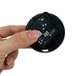 Exposed main control circuit board on black sensor module, held in hand