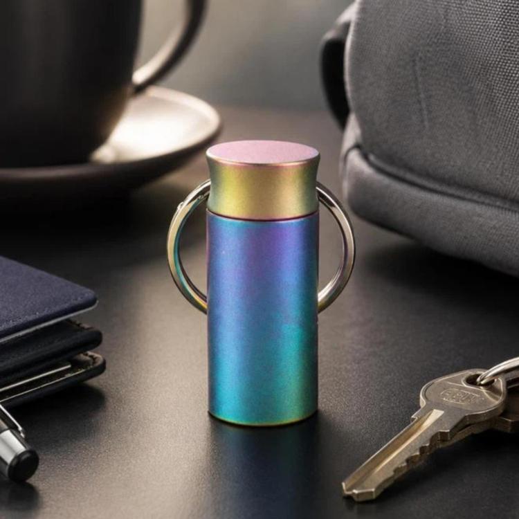 Mini sealed keychain pill case with iridescent rainbow PVD finish and metal key ring