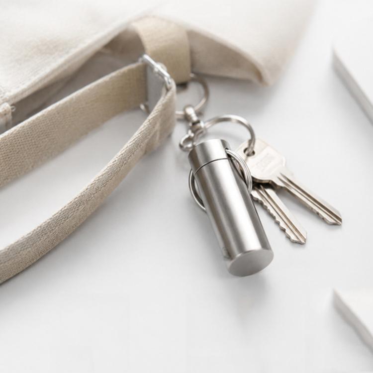 Mini sealed pill case keychain in brushed silver with metal key ring and attached keys