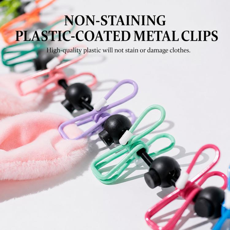 Plastic-coated metal laundry clips with colored frames and black ends on a cloth