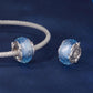 Blue glitter glass beads with silver star caps on matching metal bases