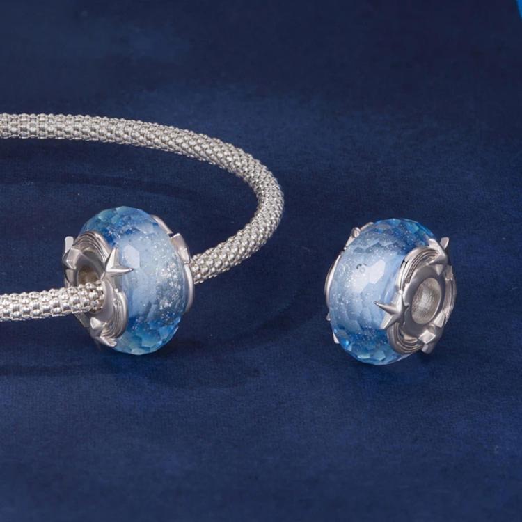 Blue glitter glass beads with silver star caps on matching metal bases