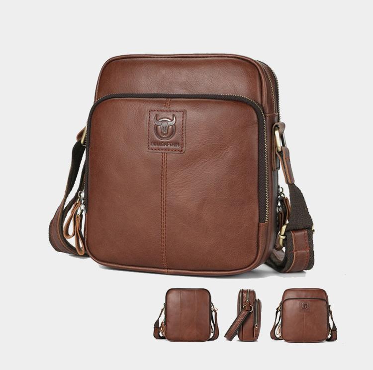 Brown leather crossbody bag with front logo emblem, zip top, and adjustable shoulder strap.