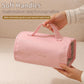 Pink roll-up makeup organizer bag held by soft top handles with detachable clear panels