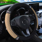Beige quilted steering wheel cover with black edge and rhinestone studded band