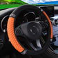 Orange quilted steering wheel cover with black edge and rhinestone studded trim