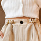 Pearl safety pin waist tightener clips fastened on light beige pants