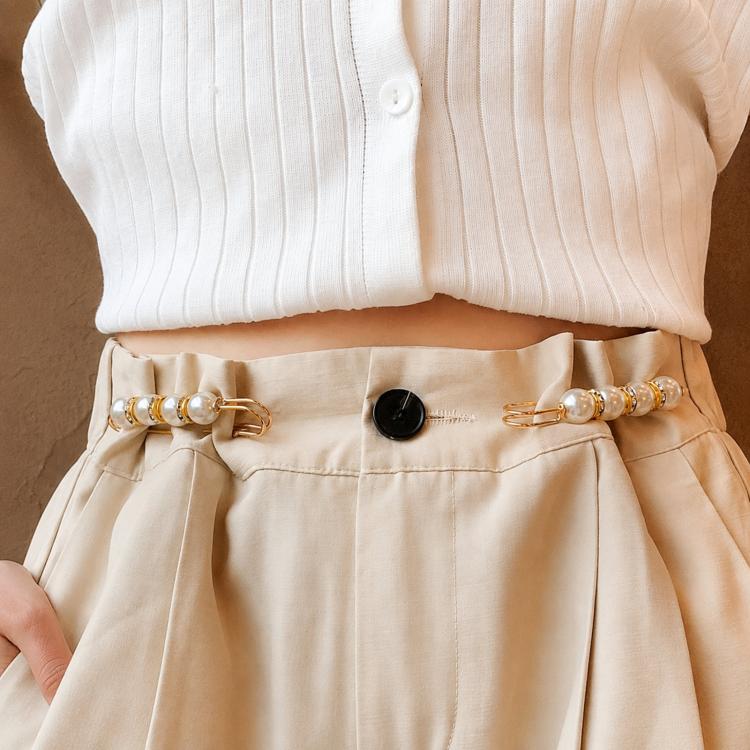 Pearl safety pin waist tightener clips fastened on light beige pants