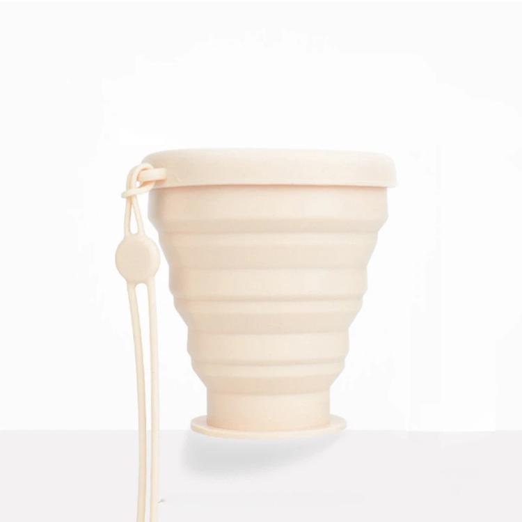 Apricot collapsible silicone travel cup with screw-on lid and hanging lanyard loop