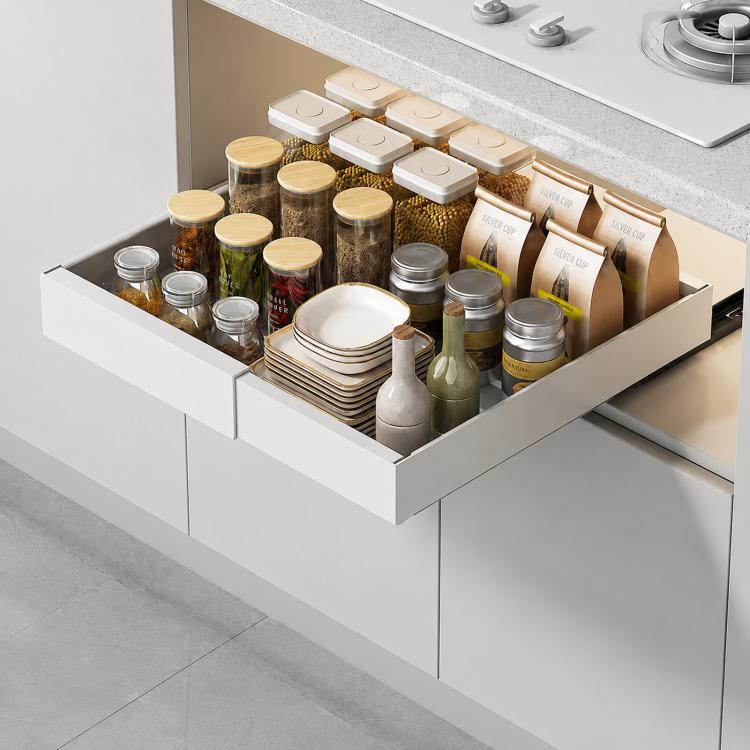 White under-sink pull-out organizer drawer expanded open, holding spices and stacked plates