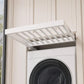 White drying rack with rod slots mounted on a washer with round door