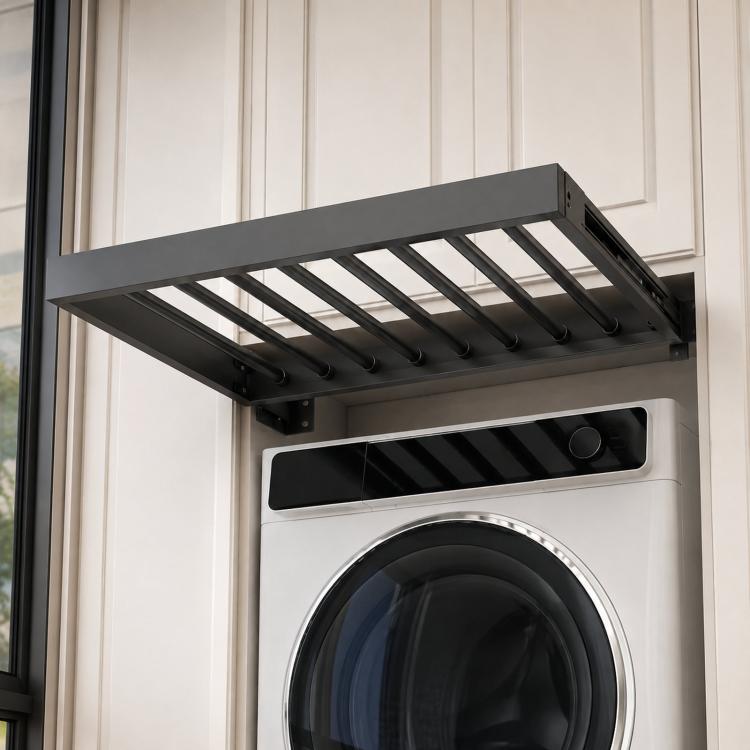 Gray extendable laundry rack with slanted rod supports above a washer front