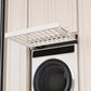 White pull-out laundry drying rack with slatted rods, extended over a front-loading washer