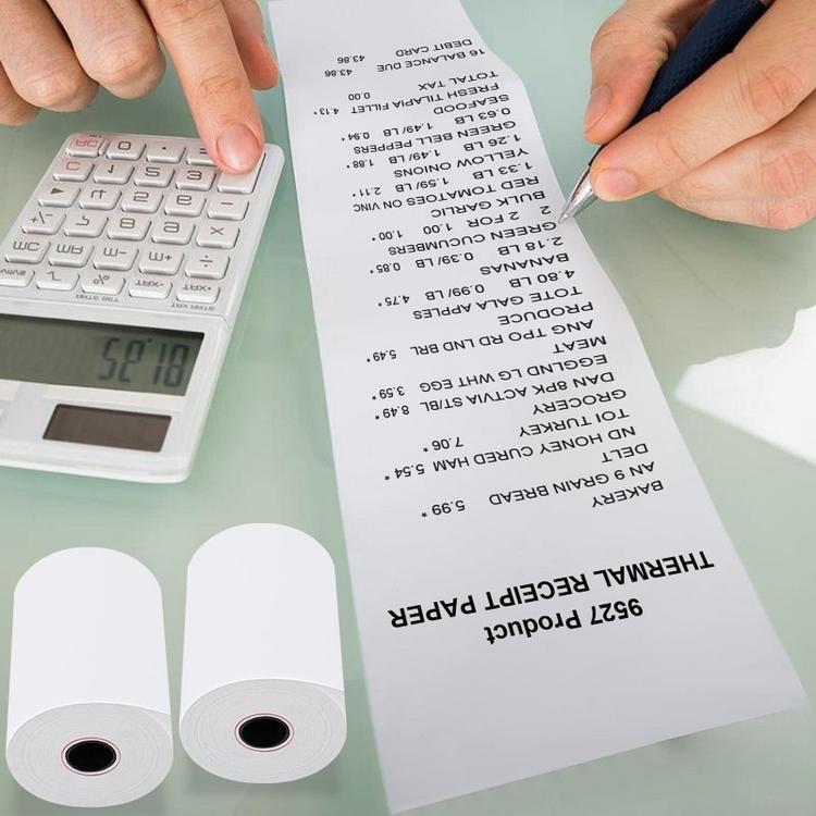 Thermal receipt paper rolls with printed receipt held in hands above a calculator