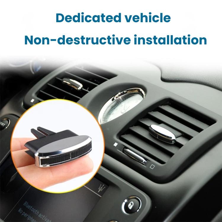 Air vent adjustment clip installed on dashboard vent, black prongs and chrome oval.