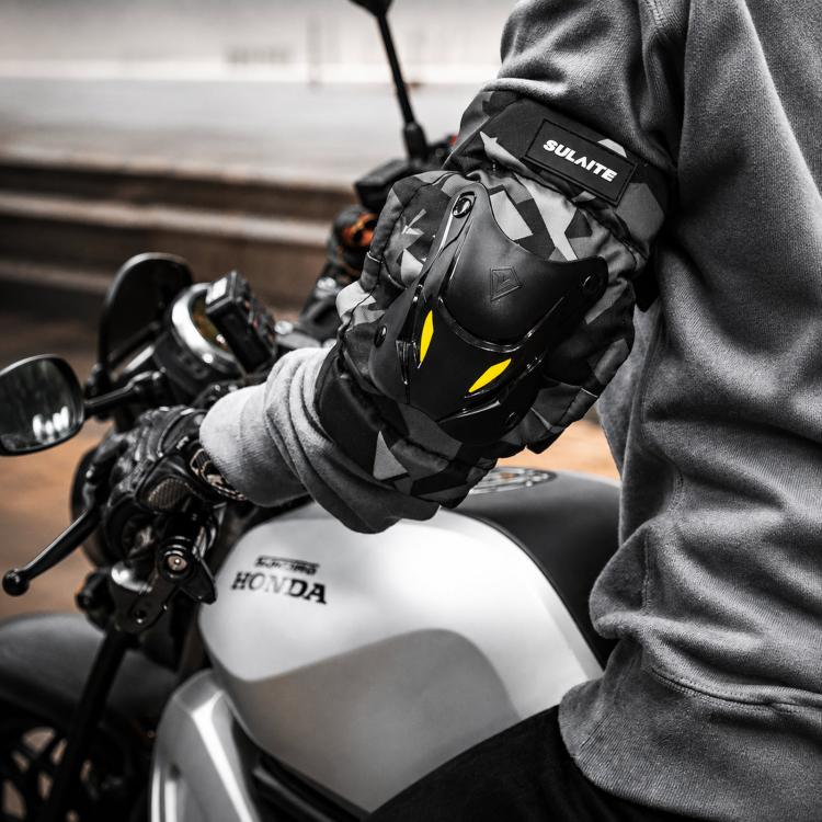 Motorcycle protective elbow and knee pads worn on rider, black/gray camo with yellow accents