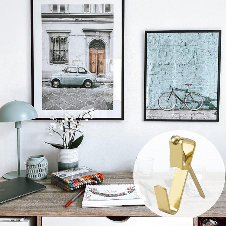Gold picture hanging hooks mounted on wall to hold keys or small frames